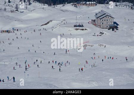 Les skieurs de ski de jeu sur une piste de ski dans le domaine skiable de Madonna di Campiglio, une destination populaire de vacances dans la région des Alpes du nord de l'Italie de la Banque D'Images