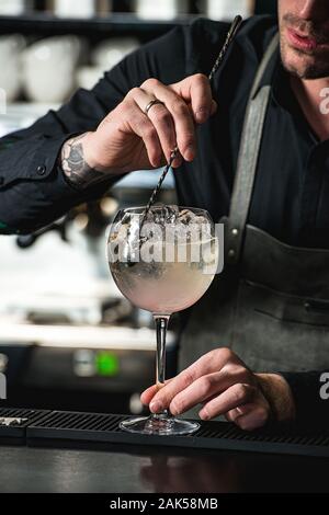 Bartender making rouge rubis rafraîchissante avec cocktail de fruits raisin isolé sur fond d'un bar Banque D'Images