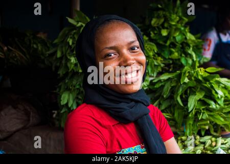 Jeune femme africaine heureux de vendre dans un marché local smiling Banque D'Images