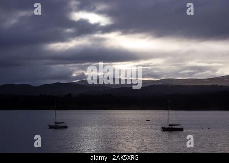 Deux voiliers sur le Loch Insh au crépuscule avec une montagne en arrière-plan, photographié dans le Parc National de Cairngorms, en Écosse Banque D'Images