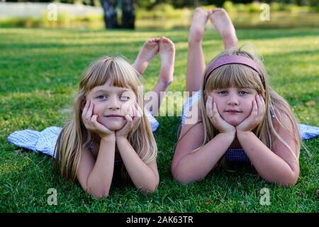 Deux jeunes filles, frères et sœurs se trouvant sur la prairie avec la tête appuyée, 6 et 7 ans, portrait, République Tchèque Banque D'Images