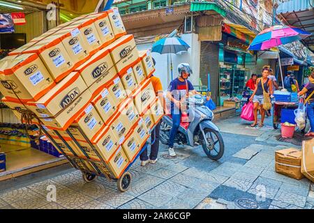 BANGKOK, THAÏLANDE - 15 avril 2019 : le porteur tirant le chariot avec le tas de boîtes dans le marché de Chinatown, le 15 avril à Bangkok Banque D'Images