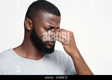 L'homme afro fatigué touchant son nez pont, souffrant d'une douleur oculaire, yeux fatigués, copy space Banque D'Images