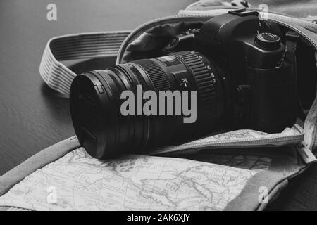 L'appareil photo est dans un sac de voyage qui se trouve sur une surface en bois Banque D'Images