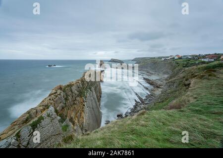 Falaises abruptes et formations rocheuses en couches surplombant les eaux turbulentes le long de la Costa Quebrada dans le nord de l'Espagne. Banque D'Images