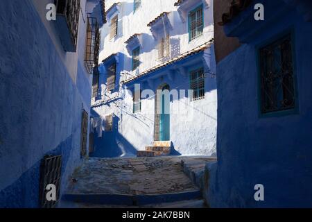 La rue éclipsée et le mur ensoleillé du bâtiment de la médina de Chefchaouen (également connu sous le nom de Chaouen), Maroc Banque D'Images