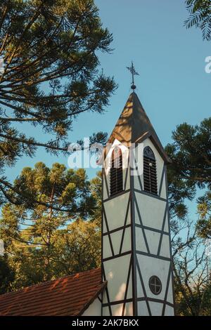 Beffroi de l'église entre plusieurs arbres au parc Village d'immigrants de Nova Petropolis. Une ville fondée par des immigrants allemands dans le sud du Brésil. Banque D'Images