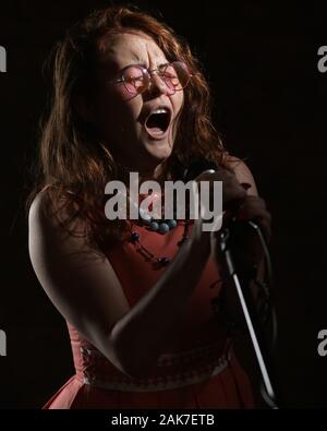 Septembre 2019 - Une Janis Joplin inspiré tirer avec une jeune femme à la tête rouge dans le studio, à Bristol. Banque D'Images