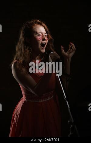 Septembre 2019 - Une Janis Joplin inspiré tirer avec une jeune femme à la tête rouge dans le studio, à Bristol. Banque D'Images