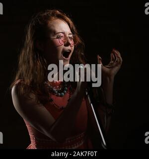 Septembre 2019 - Une Janis Joplin inspiré tirer avec une jeune femme à la tête rouge dans le studio, à Bristol. Banque D'Images