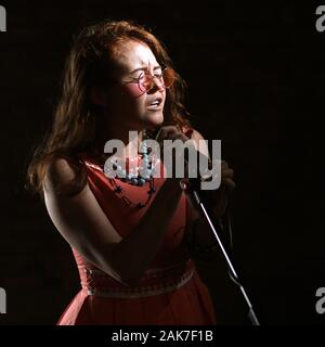 Septembre 2019 - Une Janis Joplin inspiré tirer avec une jeune femme à la tête rouge dans le studio, à Bristol. Banque D'Images