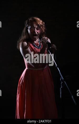 Septembre 2019 - Une Janis Joplin inspiré tirer avec une jeune femme à la tête rouge dans le studio, à Bristol. Banque D'Images