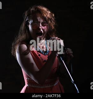 Septembre 2019 - Une Janis Joplin inspiré tirer avec une jeune femme à la tête rouge dans le studio, à Bristol. Banque D'Images