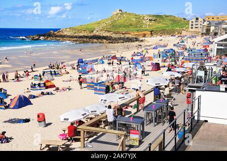 Les vacanciers profitant du soleil sur la plage de Porthmeor en plein été à la populaire station balnéaire de St Ives en Cornouailles, Angleterre, RU Banque D'Images