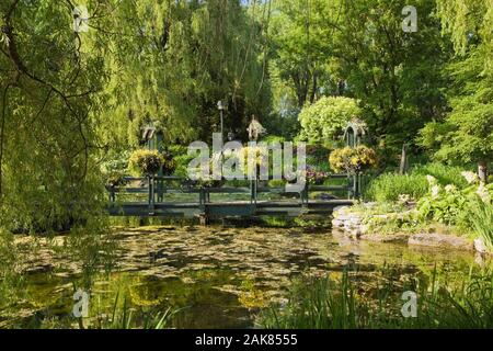 Étang et pont à travers les branches des arbres au printemps, Centre de la Nature, Saint-Vincent-de-Paul, Laval, Québec, Canada. Banque D'Images