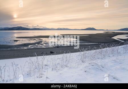 Neige sur une plage dans le sud-est de l'Alaska à marée basse avec un ciel de coucher du soleil. Banque D'Images