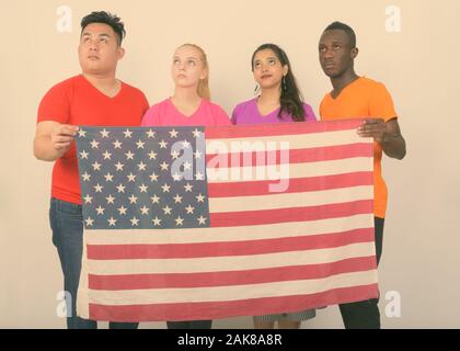 Portrait de groupe d'amis multi ethnic penser tout en tenant le drapeau Américain ensemble Banque D'Images