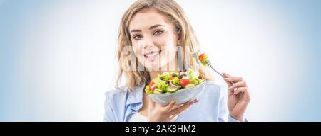 Jeune fille blonde heureux de manger sain salade. Banque D'Images