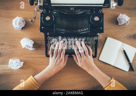 Écriture sur la machine à écrire vintage avec des papiers froissés autour. Concept de problème d'inspiration Banque D'Images