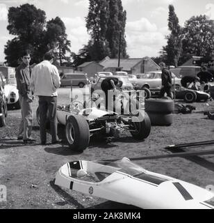 Années 1960, historiques, mécaniciens travaillant sur les voitures de course de l'époque à Crystal Palace Park, Crystal Palace, le sud de Londres, Angleterre, Royaume-Uni. Crystal Palace est l'un des plus anciens sites de sport automobile la plus au monde puisqu'elle a organisé la première course automobile en 1899. Le circuit fermé en 1972. Banque D'Images