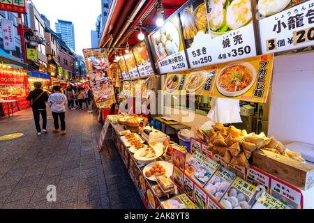 Chinatown, Nankin-Machi, Kobe, Japon. Vue sur le comptoir d'un Chinese street food en premier plan avec d'autres stands dans l'arrière-plan. La nuit. Banque D'Images