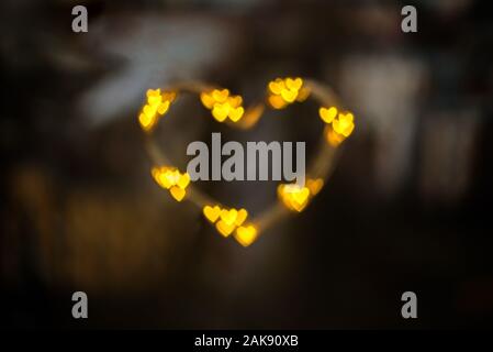 Coeur fait de petits cœurs sur fond sombre Banque D'Images