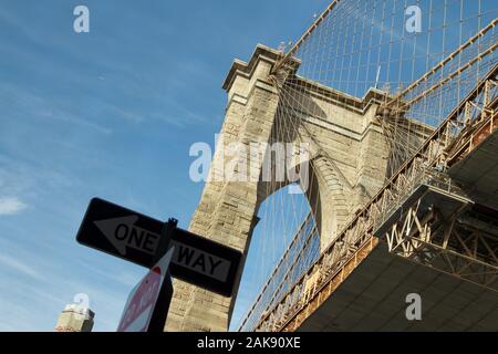 Image emblématique du pont de Brooklyn, à la recherche d'un jour bleu avec une façon street sign en premier plan. Pont suspendu avec des fils de Pierre vu de regarder faible Banque D'Images
