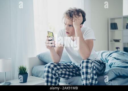 Omg... J'ai besoin de boire moins d'alcool. Portrait de guy négatifs impressionnés après parti ont gueule maux utilisation cellulaire trouvé drôle in blogs Banque D'Images