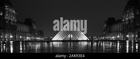 Vue nocturne symétrique de la pyramide du Louvre à Paris Banque D'Images