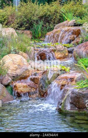 Petite cascade sur les rochers en cascade avec le feuillage Banque D'Images