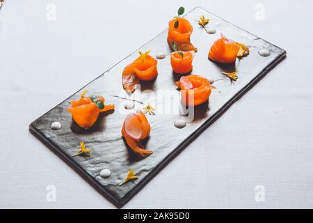 Les tranches de saumon sur des dalles en ardoise noire du poisson cru, sushi Banque D'Images