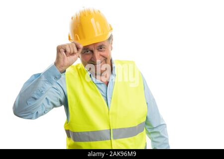 Vieux homme builder toucher casque avec la main, comme salut déférent isolé sur fond blanc Banque D'Images