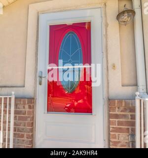 Square de l'extérieur d'un accueil avec des carreaux de verre ovale rouge vibrant porte avant Banque D'Images