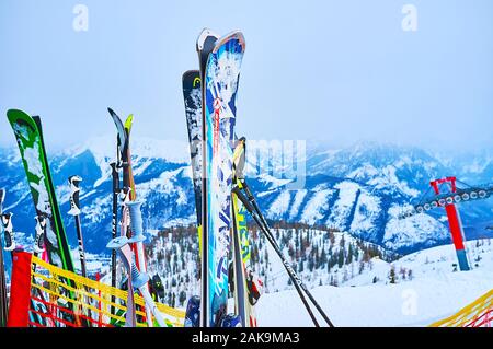 EBENSEE, Autriche - 24 février 2019 : les skis et bâtons, coincé dans la neige sur le bord du mont Feuerkogel avec vue sur les chutes de neige dans les Alpes misty Banque D'Images