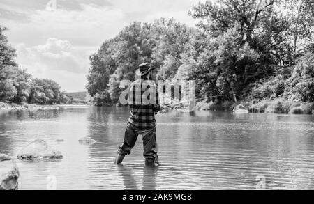 Pêche avec remise à l'eau. Dans l'eau. Pêcheur barbu mature man fly fishing. man la capture de poissons. pêcheur avec canne à pêche week-end d'été.. La pêche au gros. passe-temps et les activités sportives. pothunter. Banque D'Images