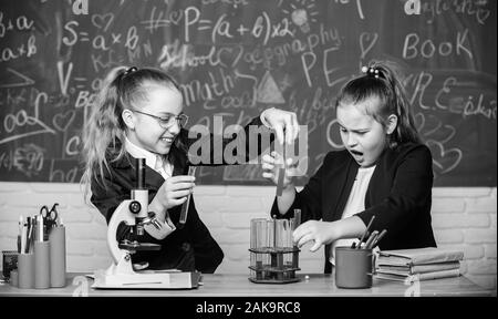 Microscope et de tubes à essai sur table. Expérience Pédagogique concept. Attention l'exécution de la réaction chimique. Connaissances de base en chimie. Les filles étudient la chimie. Faire en chimie intéressant. Banque D'Images