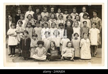 Au début des années 1900 photographie carte postale de l'école les filles et enseignant à l'École Conseil John Street, Salford, Lancashire, Angleterre, Royaume-Uni, vers 1920. Banque D'Images