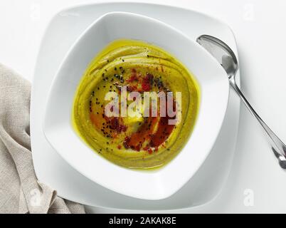 Soupe crème de brocoli et pommes de terre avec, servi avec le paprika fumé et graines de sésame noir isolé sur blanc, par le dessus Banque D'Images