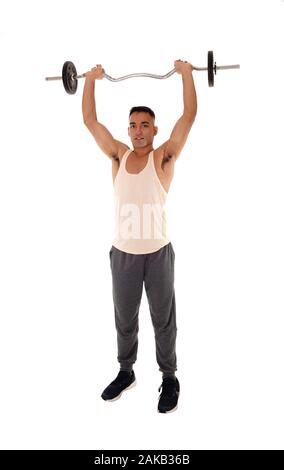 Un grand jeune homme debout dans le studio en tenue d'exercice un certain poids de levage au-dessus de sa tête, isolée pour fond blanc Banque D'Images