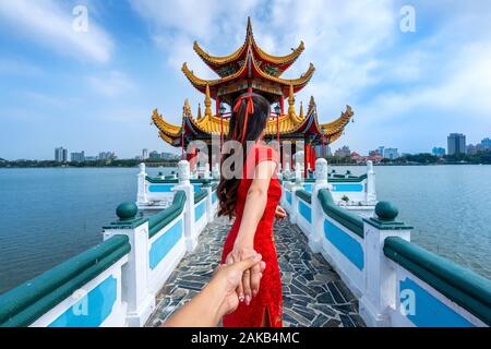 Les femmes touristes titulaires la main de l'homme et le conduisant à de célèbres attractions touristiques de Kaohsiung à Taiwan. Banque D'Images