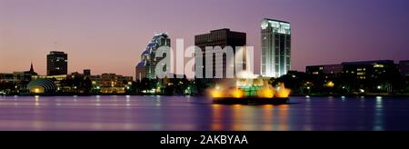 Fontaine dans un lac éclairé la nuit, le lac Eola, Summerlin Park, Orlando, Orange County, Floride, États-Unis Banque D'Images