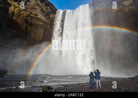 L'Islande, Sudurland, Skogar, arc-en-ciel en face de Skogafoss Banque D'Images