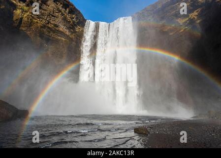 L'Islande, Sudurland, Skogar, arc-en-ciel en face de Skogafoss Banque D'Images