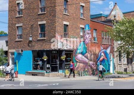 Canada, Province de Québec, Montréal, quartier Plateau-Mont-Royal, rue Rachel, Clandestinos wall par Bruno Smoky et attaque Shalak, Café Névé, de cyclistes et de passants Banque D'Images