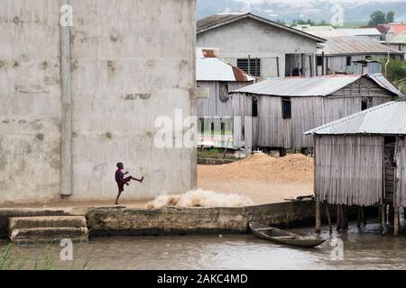 Le Bénin, ville au bord du lac de Ganvié, kid jouer en face de filets de pêche Banque D'Images