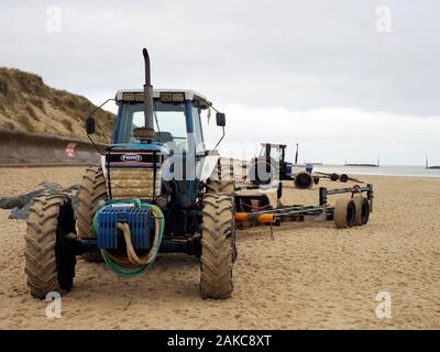 Tracteurs rouillés une remorques bateaux utilisés par les pêcheurs de lancer et de récupérer leurs bateaux sur la plage à Sea Palling, Norfolk. Banque D'Images