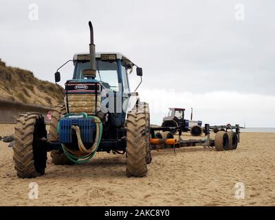 Tracteurs rouillés une remorques bateaux utilisés par les pêcheurs de lancer et de récupérer leurs bateaux sur la plage à Sea Palling, Norfolk. Banque D'Images