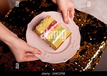 Brillant d'or gâteau savoureux est coupé en morceaux. Une tranche de gâteau sur une plaque rose. La cuisson à la maison pour une fête pour les enfants. Banque D'Images