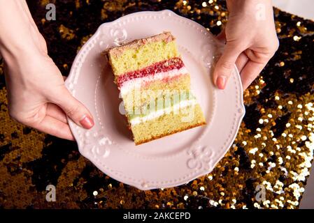 Brillant d'or gâteau savoureux est coupé en morceaux. Une tranche de gâteau sur une plaque rose. La cuisson à la maison pour une fête pour les enfants. Banque D'Images