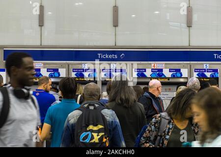 Les navetteurs en attente pour les distributeurs de billets automatiques à la gare de Kings Cross, London, UK Banque D'Images